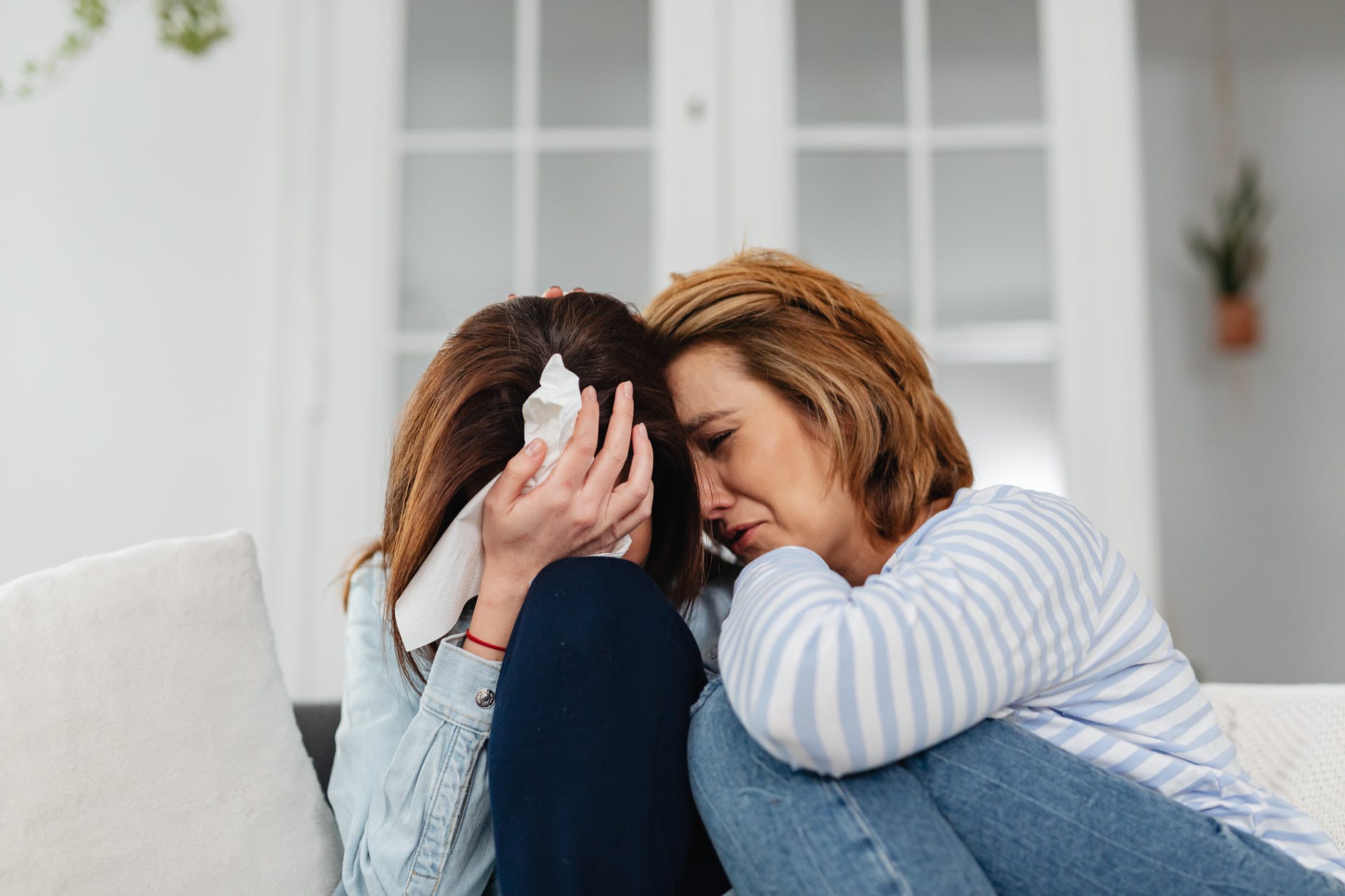 two women friends crying together